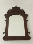 Lote 511 - Espelho biselado com moldura de madeira trabalhada, com 100x53 cm