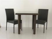 Lote 548 - Conjunto de jardim composto por mesa e 2 cadeiras de ratan sintético de tom escuro, mesa com tampo de vidro temperado com 75x90x90 cm e cadeiras com 87x43x45 cm