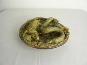 Lote 580 - Prato das Caldas em relevo com carimbo/marcas Mafra, antigo, decorado com "ninho de cobra e lagartos"de tons verde e amarelo, com 18 cm de diâmetro (apresenta pequenos restauros) 