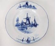 Lote 1460266 - Prato de porcelana com bordo recortado, friso azul decorado com moinhos e barco em tons de azul, com 23,5 cm de diâmetro (apresenta defeito)