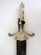 Lote 1560258 - Réplica de espada com cabo em metal decorado com motivo guerreiro, com baínha de pele sintética preta, com 95 cm de comprimento