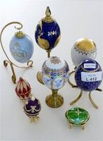 Lote 412 - Conjunto de 5 ovos de Páscoa em porcelana e metal com dourados, edição das Colecções Philae e 3 réplicas de ovos Fabergé, com medidas entre 6 cm e 22 cm de altura