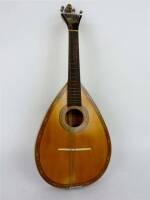 Lote 455 - Bandolim de madeira decorado com friso com embutidos, com 6x23x61 cm, interior da peça apresenta uma etiqueta com nº de conserto, pertencente à Guitarraria Leiriense, instrumento com falha de 4 cordas 