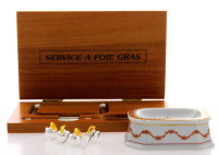 Lote 4278 - Conjunto formado por saleiro em porcelana da Vista Alegre, marca verde, conjunto para cortar foie gras composto de espátula e cortador de arame com estojo em madeira e 4 marcadores de lugar em metal prateado e dourado da Asprey de londres com 