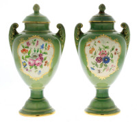 Lote 4721 - Par de urnas com tampa em faiança de Sacavém, marcadas Gilman, com decoração monocroma verde e reservas policromadas com flores. Asas relevadas. Tampas encimadas por pináculos. Dim: 23 cm. Notas: decoração desenhada e assinada por Sir Nigel Ro