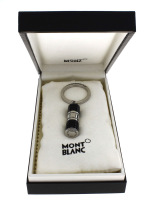 Lote 4755 - Porta Chaves Montblanc, modelo 107600, em aço e resina preta. Dim: 7,5 cm. Porta chaves idêntico à venda por € 175 em http://www.stylos-luxe.com/montblanc-bijoux-porte-cles/589-porte-cles-montblanc-en-acier-fin-incruste-d-onyx.html . Notas: em