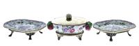 Lote 4967 - Conjunto formado por pequena terrina em porcelana da china com decoração floral policromada com tampa e pés em casquinha e 2 travessas em porcelana com decoração floral policromada e pés em casquinha. Dim: 8x14x9 cm (terrina) e 3,5x14,5x11 cm 