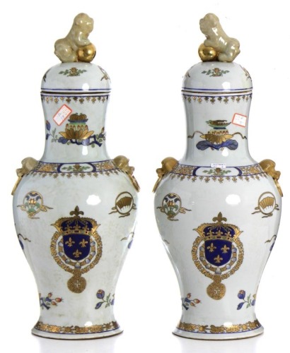 Lote 5076 - Par de potes com tampa em porcelana chinesa, decoração floral e reservas com brasões de armas policromada com dourados, tampa com figura de cão de foo em relevo, dim: 56cm.