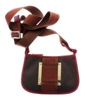 Lote 4534 - Carteira de senhora marca Fendi, Made in Italy, original (Reg. A 294379), modelo de pôr ao ombro com alça larga, com 2 divisórias, em tela debruada a pele bordeaux, com placas de metal dourado com Logo da marca, com 14x22x3 cm, em bom estado