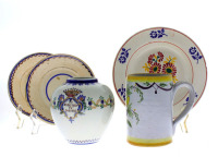 Lote 153 - Conjunto de cerâmica composto por três pratos fundos com decoração policromada motivo floral, um pote com decoração floral e brazão com dizeres marcada na base "cavalinho", caneca policromada pintada manualmente com flor. Dim: entre 14x9,5 cm (