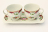 Lote 6 - Duas chávenas com prato retangular em porcelana M.A.B.A., com decoração tipo Limoges de motivos florais policromados e dourados, marcadas na base, com 7x17x8,5 cm. Bom estado geral, ligeiros sinais de uso.