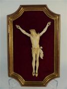 Lote 730 - Imagem de Cristo Crucificado talhado em osso, com 20x12,5 cm, peça montada sobre veludo vermelho com moldura dourada
