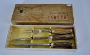 Lote 1650355 - Conjunto de trinchar de aço inoxidável com cabo de chifre de veado, composto por garfo e faca de trinchar e amolador em caixa original "Stag Handle Carvers" made in Sheffield, England, usado, com falhas