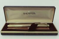 Lote 255 - Caneta de tinta permanente de marca SHEAFFER U.S.A Targa 1005 Medium Anos 60 . Corpo em plaqué de ouro de ótima qualidade lacado a preto nas extremidades. Aparo gravado oficialmente em ouro de 14k (au 585). Em estojo original com certificado. N