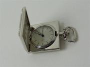 Lote 1720144 - Relógio de bolso, quartz, em metal prateado, com caixa quadrada, com 3x3 cm, falta de pilha, usado