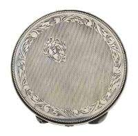 Lote 4037 - CAIXA DE PÓ DE ARROZ EM PRATA 833 SÉC XX - Caixa com decoração cinzelada em guilhoché e motivos vegetalistas. Peso: 98 g. Dim: 9 cm. Valor estimado de € 200 em ourivesaria. Nota: com marcas de contraste, sinais de uso