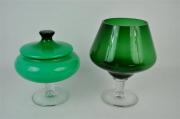 Lote 1202 - Lote composto por taça de pé em forma de cálice em vidro verde, com 28 cm de altura e taça com tampa em vidro verde, com 25 cm de altura