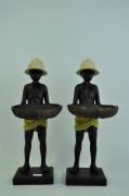 Lote 1770339 - Par de estatuetas em resina com figura de menino africano com chapéu colonial a segurar cesto, 38 cm de altura