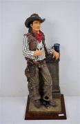 Lote 395 - Estatueta de cowboy em massa pintada, com cerca de 50 cm de altura