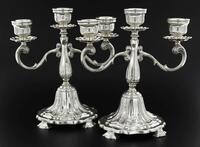 Lote 6198 - PAR DE CANDELABROS EM PRATA 833 SÉC XIX/XX - Três lumes, corpo decorado com enrolamentos vegetalistas relevados e base assente sobre quatro pés. Peso total: 1.222 g. Dim: 22 cm (altura). Valor estimado de € 3.000 em ourivesaria. Nota: sinais d