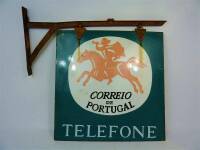 Lote 11 - Placa esmaltada dos CTT – CORREIOS DE PORTUGAL, serigrafada de ambos os lados, com 55x55 cm, com o suporte original em ferro de fixação à parede, com 74x35 cm, sinais de uso e ferrugem