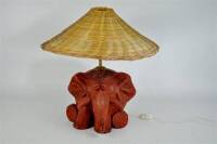 Lote 2060134 - Candeeiro de mesa em barro, em forma de elefante, feito à mão e assinado, com abat-jour em palhinha, com 57 cm aproximadamente