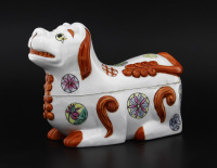 Lote 113 - PORCELANA ORIENTAL, CAIXA - Figura de cão deitado, decoração policromada. Dim: 15x23x12 cm. Nota: sinais de uso