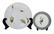 Lote 26 - CONJUNTO EM FAIANÇA - Composto por 2 pratos, 1 Vista Alegre e 1 Sociedade de Porcelanas de Coimbra. Decoração vegetalista. Dim: 19 cm (prato maior, S.P. Coimbra). Nota: sinais de armazenamento. Em bom estado