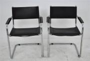 Lote 1595 - Par de cadeiras estilo Wassily Marcel Breuer, estrutura em tubular cromada, costas, assento e braços em couro preto, com 82x60x50 cm, Nota: apresenta falhas
