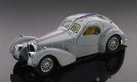 Lote 100 - BURAGO, BUGATTI ATLANTIC, 1936 - Miniatura à escala 1:24, metal cinzento prateado. Made in Italy. Nota: desgastes, falhas na pintura e no farol dianteiro direito