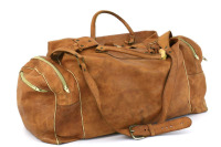 Lote 76 - SACO DE VIAGEM EM PELE - Modelo vintage em cor castanho camel, com 2 pegas de mão, alça de ombro ajustável com fivela de metal, bolsos exteriores com fechos, fecho central e pespontos. Dim: 30x60x26 cm (aprox.). Nota: sinais de uso, pega com def