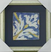 Lote 38 - AZULEJO SÉCULO XVII - Aplicado em moldura de caixa prateada. Decoração a azul e amarelo. Dim: 14x14 cm (azulejo) e 28x28 cm (moldura). Nota: falhas e defeitos