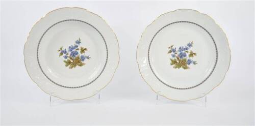 Lote 23 - Par de pratos de porcelana Vista Alegre antigos com bordo recortado, decoração de flores e friso dourado, com 32 e 33 cm de diâmetro.