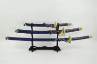 Lote 112 - Magnífico conjunto de espadas Samurai de Cerimónia, punhos revestidos com cordão, bainhas douradas ricamente trabalhadas com dragões, com 58cm, 79 cm e 103 cm e suporte em madeira com 36x40 cm 