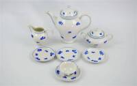 Lote 187 - Parte de serviço de chá em porcelana Vista Alegre, antigo, com decoração floral azul, composto por bule com 20 cm, açucareiro com 10 cm, leiteira com 11 cm de altura, 4 pires e 1 chávena NOTA; usado