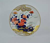 Lote 295 - Prato decorativo de porcelana Japonesa, assinado, com decoração oriental com motivos florais em azul e salmão com dourados, com 32 cm de diâmetro