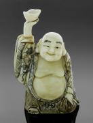 Lote 5011 - OKIMONO, BUDA EM MARFIM - Escultura Japonesa em marfim entalhado e placas de marfim, representando Buda da Abundância, com decoração grafitada. Assinado na base. Dim: 13,5x8x6 cm. Peso: 236 g