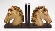 Lote 23 - CERRA-LIVROS - cerra-livros com cabeça de cavalo em marfinite sobre suporte de madeira, com 22,5x8,5x22,5 cm. Sinais de uso