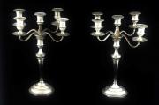 Lote 1982 - PAR DE CANDELABROS - Em metal prateado com 5 lumes, sendo possível dois tipos de diâmetro de velas através de pequenos pratos removíveis. Corpo superior com braços de candelabro removíveis ficando fuste com castiçal. Dim: 39,5x32x32 cm (aprox.). Nota: sinais de uso. Falhas e defeitos, empenos e elementos soldados