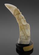 Lote 8 - ARTE TRIBAL, ESCULTURA - Representação de figura feminina em presa de facochero assente em base de madeira. Dim: 12,5x13 cm (aprox.). Nota: sinais de manuseamento