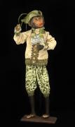 Lote 10 - FIGURA DECORATIVA - Representação de macaco vestindo trajes estilo Império em tecido, assente em base de madeira. Carnações em plástico policromado. Dim: 65x20,5x12 cm (aprox.). Nota: em bom estado