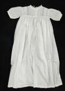 Lote 15 - VESTIDO DE BAPTIZADO, ANTIGO - Modelo para bebé, circa 1900, em tecido de algodão branco, comprido, com manga comprida, peitilho com aplicação de renda e bordado à mão, saia com franzidos, a apertar com botão forrado e fita atrás. Dim: 75 cm de comprimento e 28 cm de largura. Nota: sinais de uso, bem conservado