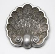 Lote 95 - CINZEIRO - Cinzeiro em metal prateado em forma de concha ricamente ornamentado com motivos vegetalistas relevados. Dimensão: 5x17x17,5 cm. Sinais de uso