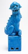 Lote 165 - CÃO DE FOO - em cerâmica oriental vidrada a azul, sobre pedestal. Dimensão: 31,5x11,5x7,5 cm. Bom estado