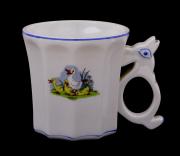 Lote 1147 - S.P. COIMBRA, CANECA JUVENIL - Decoração com patos policromados e frisos a azul, pega simulando coelho e corpo facetado. Com o respectivo carimbo na base. Dim: 8,5x8,5 cm (aprox.). Nota: sinais de uso e armazenamento. Pequenas falhas e defeitos