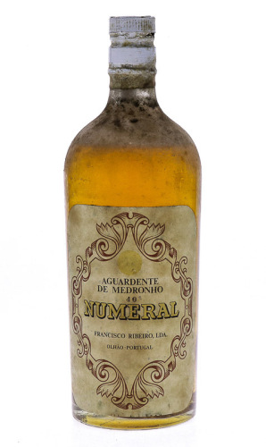 Lote 3139 - AGUARDENTE NUMERAL - Garrafa de Aguardente de Medronho Numeral, Francisco Ribeiro, Olhão, (750ml aprox - 40%vol.). Nota: apresenta perda adequada ao período de engarrafamento. Rolha algo danificada