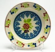 Lote 4161 - PRATO EM FAIANÇA PORTUGUESA SÉC. XIX - prato covo em faiança pintado com motivo floral no fundo envolto em rendilhado a azul, aba pintada com frutos. Dimensão: 4,5x26ø cm. Sinais de uso, fenda, ligeiras falhas no vidrado