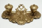 Lote 4326 - TINTEIRO VINTAGE - Tinteiro antigo estilo Luís XV em latão dourado ricamente ornamentado com mascarão, folhas de acanto e enrolamentos vegetalistas. Dimensão: 8x24,5x17 cm. Bom estado estético