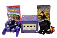 Lote 5204 - CONSOLA NINTENDO GAMECUBE - Junta com os respectivos cabos de ligação, transformador, 2 comandos e 2 jogos, sendo estes o Mario Kart e o Harry Potter. Nota: sinais de uso, liga