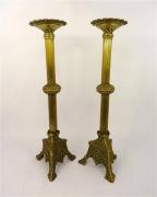 Lote 530 - Par de castiçais de bronze com decoração de canelados, base com cruz de Cristo e 3 pés, com 50 cm de altura